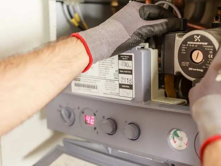Technician maintaining a residential boiler